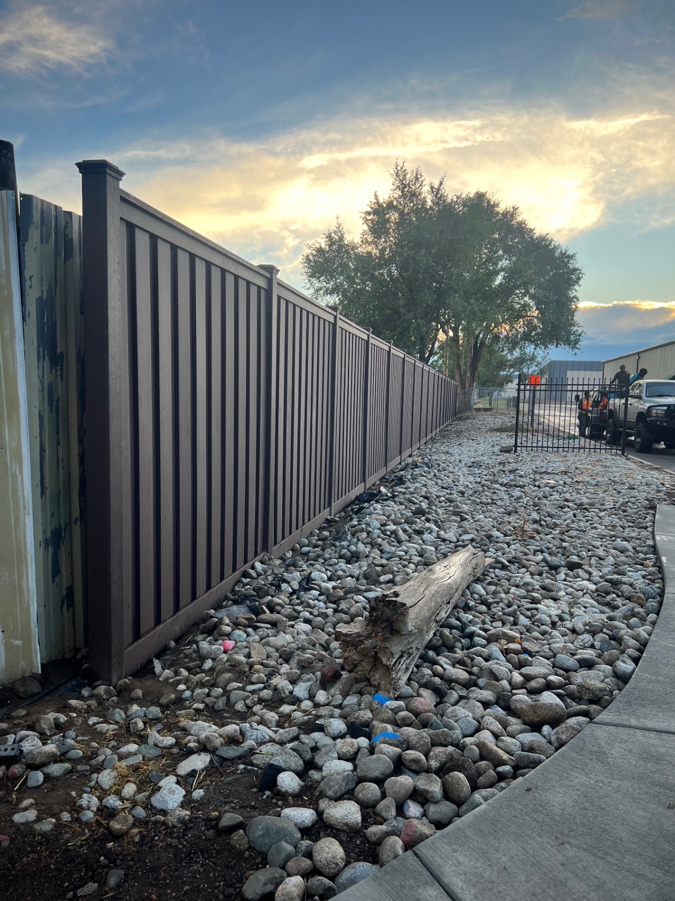 Low maintenance composite privacy fence beside a landscaped commercial walkway